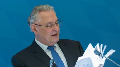 Bild: Peter Kneffel/dpa
Der bayerische Innenminister Joachim Herrmann blättert auf einer Pressekonferenz im neuen Statistischen Jahrbuch.