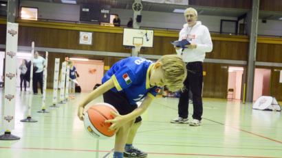 Bild: Gabi Schönberger
Unter den Augen der Neustädter Trainer (im Bild Willi Merkl) absolvieren die Jung-Basketballer (hier Niklas Puhane) den Parcours. Neben Werfen, Passen, Körperbeherrschung ist natürlich auch Dribbeln angesagt.
