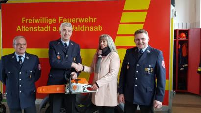 Bild: adj
Über eine Motorsäge im Wert von 1000 Euro, die Gabi Prockl überreicht, freuen sich die Verantwortlichen der Feuerwehr Altenstadt/WN.