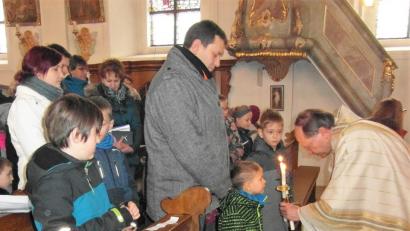Bild: hl
Mit vor dem Gesicht gekreuzten brennenden Kerzen spendet Pfarrer Heribert Stretz (rechts) auch den Kindern den Blasiussegen.