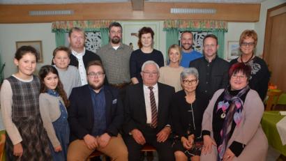 Bild: dob
Josef Schuller (vorne, Mitte) feiert 80. Geburtstag. Zu den ersten Gratulanten zählen Ehefrau Karolina und Tochter Kornelia (rechts) sowie Schullers einziger Enkel Nico (sitzend, links). Es reihen sich viele andere Gäste in die große Geburtstagsschar ein, wie Pfarrer Albert Hölzl aus Tiefenbach (hintere Reihe, links) sowie Dekan Alexander Hösl (hintere Reihe, Zweiter von rechts).