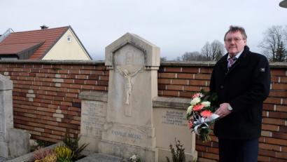 Bild: Stefanie Gradl
Bürgermeister Hans-Martin Schertl legt ein Blumengebinde am Grab des verstorbenen Altbürgermeister Rudolf Merkl nieder.