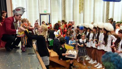 Bild: bgm
Während die Jugendgarde das Spalier zur Krapfenpolonaise bildet und die Helfer des Vereins das leckere Schmalzgebäck verteilen, überreicht Präsident Daniel Sommer eine kleine Clown-Dame, die sich auf der Bühne verirrt hatte, an deren Mama.