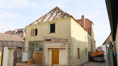 Bild: njn
Bereits am Morgen nach der Stadtratssitzung wurde damit begonnen, dass Dach des Nebengebäudes abzutragen. An dessen Stelle soll der Empfangsbereich der Tagespflegestätte sowie ein kleiner Therapiegarten entstehen.