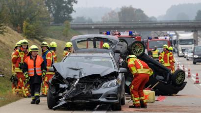 Bild: Matthias Balk
Feuerwehrmänner arbeiten rund um einen verunfallten Kombi und einen auf dem Kopf liegender Kleinwagen. Foto: Matthias Balk/Archiv