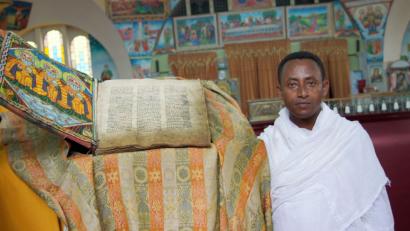 Archivbild:  Carola Frentzen/dpa
Die Kirche der Heiligen Maria von Zion im äthiopischen Axum soll Aufbewahrungsort der Bundeslade sein. Diakon Zemikael Brhane zeigt auf dieser Aufnahme von 2015 ein altes religiöses Buch in diesem Gotteshaus, das auf dem Besichtigungsprogramm der Weidener Reisegruppe der Diakonie im Oktober steht.