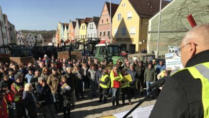 Bild: eig
Der Sprecher der Neustädter Bürgerinitiative gegen den Süd-Ost-Link, Josef Langgärtner, geißelt die Novelle des Netzausbaubeschleunigungsgesetzes. Die Demonstration vor dem Landratsamt wird begleitet von einer beachtlichen Zahl von Bauern auf großen und kleinen Schleppern.
