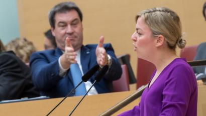 Bild: Peter Kneffel/dpa
Die Fraktionsvorsitzende von Bündnis 90/Die Grünen, Katharina Schulze, spricht im Landtag. Im Hintergrund sitzt Ministerpräsident Markus Söder (CSU).