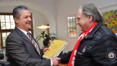 Bild: dob
Bürgermeister Andreas Wutzlhofer nimmt die von den Krematoriums-Gegnern gesammelten 926 Unterschriften von Initiator Hans Karl entgegen. „Wir werden uns nach wie vor gut verstehen“, sagt das Stadtoberhaupt. „Schon allein wegen des Vereins“, scherzt Karl mit Bezug auf die gemeinsame Vorliebe für den FC Bayern.