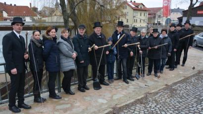 Bild: jr
In Trauerkleidung trafen sich die Verantwortlichen der Faschingsvereinigung und des Mitterteicher Gaudiwurms mit Bürgermeister Roland Grillmeier (Mitte) zum traditionellen Geldbeutelwaschen auf der Färberbrücke.