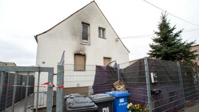 Bild: Daniel Karmann
Blumen stehen vor dem vom Feuer beschädigten Haus.