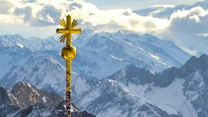 Bild: -
Das Gipfelkreuz auf der Zugspitze, an dem rechts unten einige vergoldete Strahlen abgebrochen sind. Foto: Bayerische Zugspitzbahn