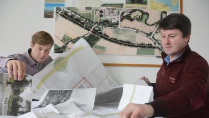 Bild: Gabi Schönberger
Eine komplexe Baustelle erfordert auch große und viele Pläne. Andreas Ettl und Manfred Schaller (von links) vom Wasserwirtschaftsamt wühlen sich durch die etlichen Pläne, Fotos und Skizzen zum Umbau des Waldnaab-Düker. Bei der Erneuerung des Dükers werden Flutkanal und Waldnaab umgeleitet.