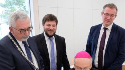 Bild: mab
Eintrag in das Goldene Buch: Bischof Rudolf Voderholzer formuliert seine ganz persönlichen Gedanken im Buch der Schwarzenfelder Ehrengäste. Mit im Bild Bürgermeister Manfred Rodde, sein Stellvertreter Peter Neumeier und der Zweite Bürgermeister der Gemeinde Schwarzach, Franz Grabinger (stehend von links).