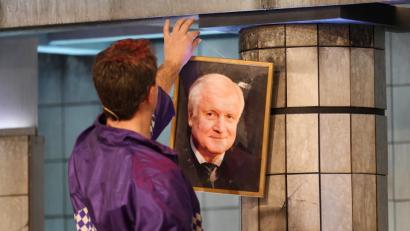 Bild: Tobias Hase/dpa
Stephan Zinner als Ministerpräsident Markus Söder hängt im Singspiel ein Bild von Horst Seehofer ab. Nach der Show kritisierte der echte Söder, dass sein Vorgänger als verwirrter Mann dargestellt wurde.