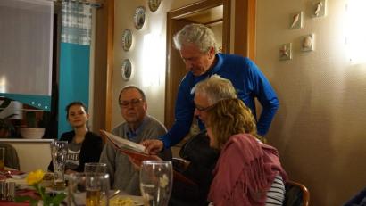 Bild: eib
Günther Borutta (stehend) erklärt Stammtischgästen Fotos und Texte in der mitgebrachten Mappe (links Organisatorin Klára Halienková, europäische Freiwillige im CeBB).