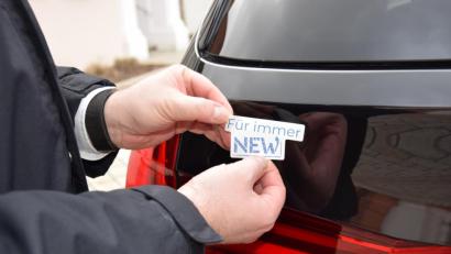Bild: exb
Landrat Andreas Meiers Dienstfahrzeug ist ab sofort auch „Für immer NEW“. Karl Lukas und Max Kallmeier von der Zulassungsstelle verteilen künftig die Aufkleber samt Info-Foldern.