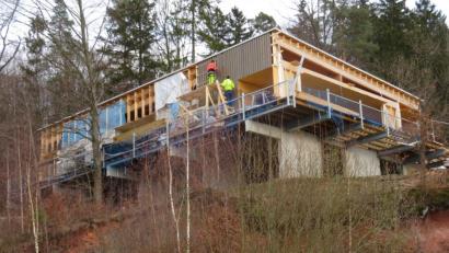 Bild: ow
Die Arbeiten am Infozentrum Rauher Kulm verlaufen schleppend. Momentan bringen die Arbeiter der finnischen Fertighausfirma die Paneele der Außenfassade an.