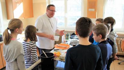 Bild: exb
Johann Lehmberger erklärt den Kindern, wie man Fisch zubereitet.