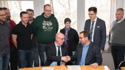 Bild: exb
Schulleiter Anton Hochberger (sitzend, links) und Professor Axel Enders besiegeln die Partnerschaft per Handschlag.