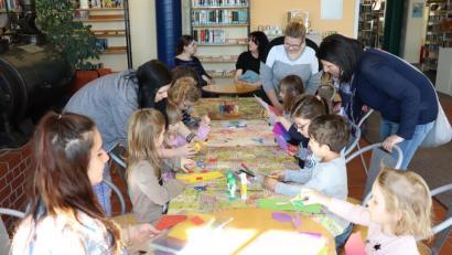 Bild: exb
Kinderhaus-Erzieherin Eva Kohl (Zweite von rechts, stehend) sowie die beiden Praktikantinnen Kim Schraml (links) und Jaqueline Haid (Zweite von links, stehend) unterstützten die Bastelaktion in der Stadtbücherei.