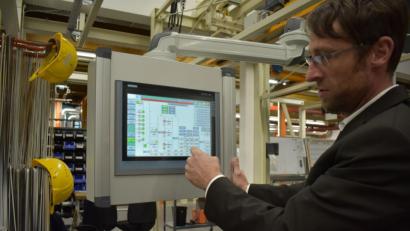 Bild: lue
Der Abteilungsleiter für Oberflächentechnik Frank Pecher zeigt, wie die neue intelligente Steuerung der Lackiereiei bei Siemens Healthineers funktioniert. Über einen Touchscreen erkennt er schnell, den aktuellen Stand in der Produktion.