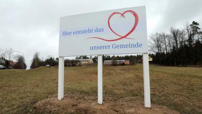 Bild: Wolfgang Steinbacher
„Hier entsteht das Herz unserer Gemeinde“, verkündet schon seit einiger Zeit ein Schild auf dem freien Gelände unterhalb der Ebermannsdorfer Schule (oranger Komplex im Hintergrund): Hier entsteht die Neue Mitte – das Ortszentrum, das Ebermannsdorf bislang nicht hat.