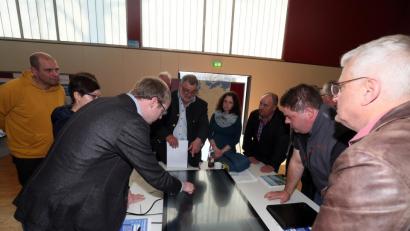 Bild: Hösamer
Eine Reihe von Anwohnern aus Lissenthan scharte sich mit Bürgermeister Armin Schärtl (Vierter von links) um das Display, auf dem Torsten Grampp (Dritter von links) von Tennet den Trassenverlauf erläuterte.