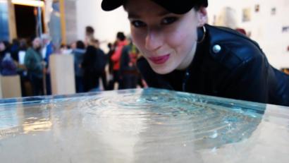 Bild: exb
Miriam Ferstl pustet auf die Wasseroberfläche der gläsernen Skulptur, die von Yoko Ono für das "Water Event" in Leipzig ausgewählt wurde.