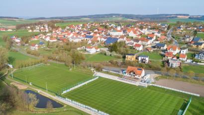 Bild: Thilo Hierstetter
Die im Tal unterhalb der Ortschaft gelegene Sportanlage der DJK Gebenbach soll an die vom Bayerischen Fußballverband geforderten Regularien angepasst werden. Dabei ist von Kapazitätserweiterung, eigenem Gästeblock und Sicherung der Rettungswege ebenso die Rede wie von einer Einbahnstraßen-Regelung rund um das Gelände. Zudem müsste gewährleistet werden, dass Spieler beim Betreten des Rasens nicht mit Zuschauern in Berührung kommen.