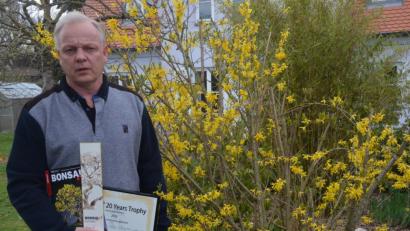 Bild: Kunz
Frank Jesse vor einem blühenden Forsythienstrauch mit seinen Auszeichnungen. Auf dem Titelbild der Fachzeitschrift "Bonsai Art" ist seine prämierte Forsythie zu sehen.