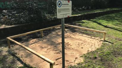 Bild: André Winkel
Ein Hundeklo aus Sand und abgrenzenden Holzstreben befindet sich auf einer Rasenfäche. Foto: André Winkel/Stadt Nürnberg