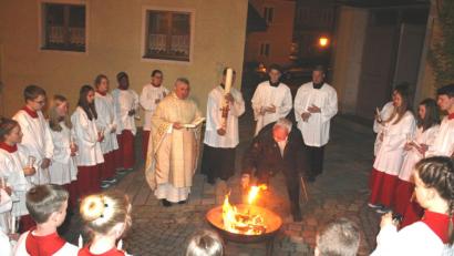 Bild: lg
An der eisernen Feuerschale vor dem Kirchenportal wurde im Kreise der Ministrantenschar die Osterkerze entzündet.