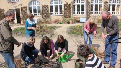 Bild: kro
Obstbaum- und Heckenabfälle werden von den Teilnehmern zusammengeschnitten, ehe sie zu Holzkohle verwandelt werden. Links der Leiter dieses Workshops, Erwin Strama.