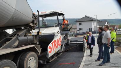 Bild: fz
Sandro Spickenreuther, Gunther König, Bürgermeister Gerhard Scharl (vorne, von rechts) und Markus Schieder beobachten, mit welcher Präzision der Asphaltfertiger die Feinschicht aufzieht.