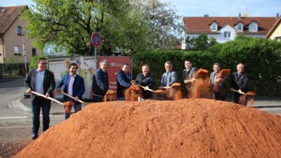 Bild: sns
Gemeinsam mit Landrat Thomas Ebeling und Bürgermeister Martin Birner nehmen die am Bau beteiligten Firmen und Kommunalverbände den Spatenstich für den Ausbau der Kreisstraße vor.