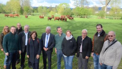 Bild: Kunz
Im Hintergrund grast Lars mit seinen Kühen. Vorne informieren sich CSU-Mitglieder über die Zucht von Angus-Rindern.
