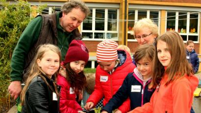 Bild: R. Kreuzer
Die Kinder pflanzten mit dem Gärtnermeister Andreas Gloßner (links) und Maria Müller (hinten) Sämlinge und Salatpflanzen in die vorbereiteten Anpflanzkisten. Nun heißt es gießen und beobachten, ehe die ersten Radieschen oder Schnittlauch geerntet werden kann.