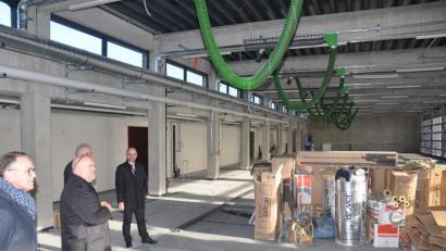 Bild: ws
In der Fahrzeughalle im Feuerwehrhaus ist auch modernste Absaugtechnik für die Autos angebracht. Die Schläuche an der Decke werden an den Auspuffanlagen angedockt. Beim Verlassen der Halle "fahren" die Schläuche mit und werden dann automatisch am Tor abgekoppelt. Architekt Peter Brückner (Zweiter von links) erläuterte dem Stadtrat die Einrichtung.