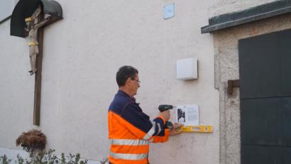 Bild: du
Gemeindearbeiter Karl Bodensteiner bringt die Info-Tafeln an den historischen Gebäuden der Gemeinde an. Hier erhält der Eingang der aus dem 12. Jahrhundert stammenden Jakobuskirche, die bis 1958 Pfarrkirche von Schirmitz war, ihr Hinweisschild.