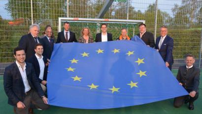 Bild: jr
Mit der Europafahne präsentierte der Jugendrat Ministerin Kerstin Schreyer (Mitte) das „Spielfeld der Begegnung“, das mit EU-Fördergeldern gebaut wurde.