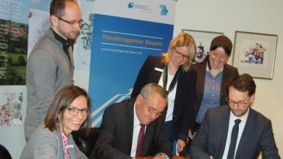 Bild: exb
Oberbürgermeister Kurt Seggewiß (Mitte) und Florian Neumann, Leiter der Transferagentur Bayern, unterzeichnen die gemeinsame Zielvereinbarung zwischen Kommune und der Einrichtung der Metropolregion Nürnberg.