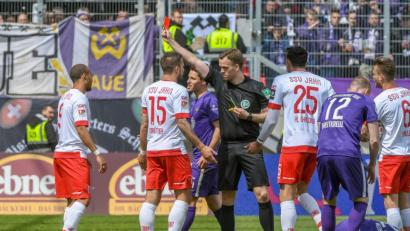 Bild: agentur_dpa
Die Schlüsselszene der Partie: Regensburgs Jann George (links) muss mit Gelb-Rot vom Platz. Binnen drei Minuten erachtet Schiedsrichter Pascal Müller (Vierter von links) zwei Vergehen des Jahn-Angreifers als gelbwürdig. Aus dem folgenden Freistoß kassiert der SSV auch noch das 0:1.