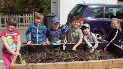 Bild: mmj
In eines der Hochbeete wurde Samen für rankende Blumen gestreut und im anderen Kartoffel gesteckt. Dort können die Buben und Mädchen vom “Club Natur” in den kommenden Wochen das Wachsen des Kartoffelkrauts verfolgen. Schon jetzt sind alle auf die Ernte der Knollen im Herbst gespannt.