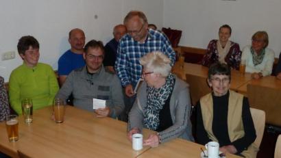 Bild: Portner
OGV-Vorsitzender Karl Ruhland (stehend) referierte über insektenfreundliche Gärten. Dazu stellte er den Mitgliedern eine Saatmischung des Landesverbands für eine Blumenwiese vor.