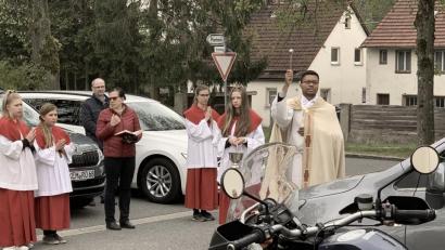 Bild: mez
Kaplan Justin Kishimbe segnet rund ein Dutzend Fahrzeuge auf dem Herz-Jesu-Kirchplatz, darunter auch zwei Motorräder.