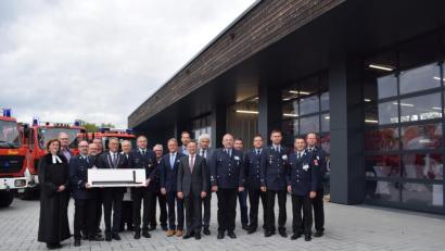 Bild: szl
Das neue Gerätehaus der Tirschenreuther Feuerwehr wurde am Freitagnachmittag feierlich eingeweiht. Statt mit dem üblichen Schlüssel überraschte Peter Brückner (Vierter von links) Bürgermeister Franz Stahl und die Führungskräfte mit einer künstlerischen Darstellung des Feuerwehrhauses, das schon allein aufgrund der ungewöhnlichen dunklen Verkleidung mit angekokeltem und damit wetterfest gemachtem Holz für Gesprächsstoff sorgt.
