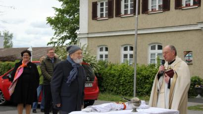 Bild: ads
Im Beisein des Zeitzeugen Wolfgang Babl (mit Mütze) segnete Pfarrer Ludwig Gradl (rechts) das weiße Banner als Friedenssymbol.