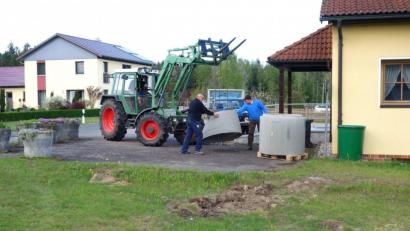 Bild: fjo
Durch die Unterstützung von Hubert Wildenauer (rechts) und Fabian Forster (im Traktor) ging die Anlieferung der Beton-Fertigteile für Hauptinitiator Ewald Zetzl reibungslos über die Bühne. Auf der Rasenfläche davor zeugen Erdarbeiten bereits vom künftigen Standort des neuen Dorfbrunnens.
