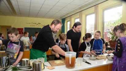 Bild: bey
"Chefkoch" Andreas Meier (links) und Schulleiter Andreas Koblen, Bor, bereiten mit Unterstützung der Kinder das Menü vor.